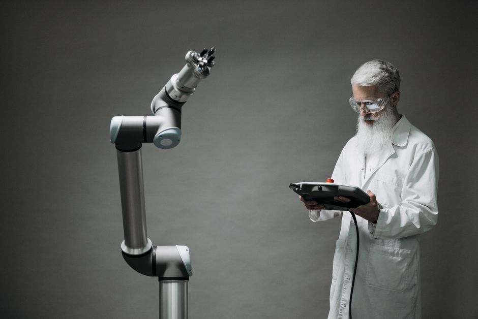 Scientifique manipulant un bras robotique dans un laboratoire.