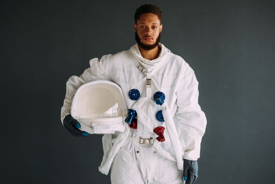 Astronaute en combinaison spatiale blanche tenant un casque