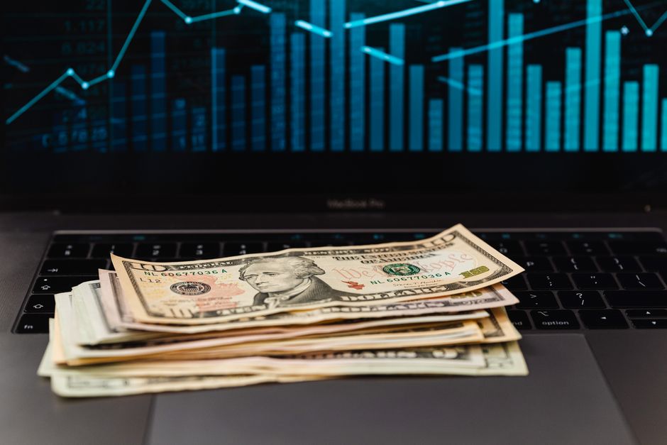 Des billets de dollars américains posés sur un clavier d'ordinateur