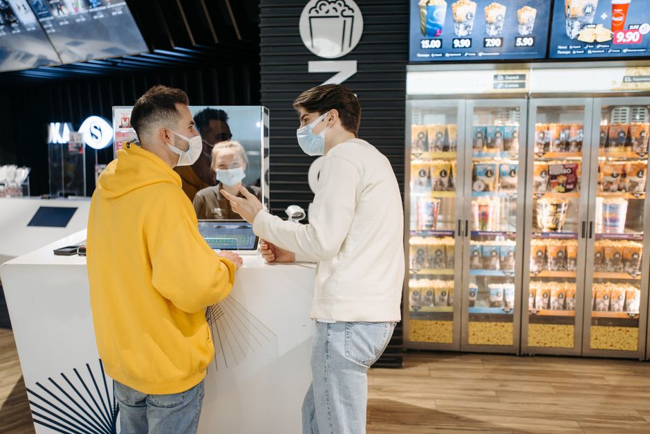 Deux personnes à un comptoir de vente de billets et friandises