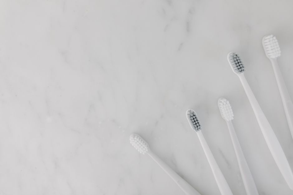 Brosses à dents blanches alignées sur une surface en marbre