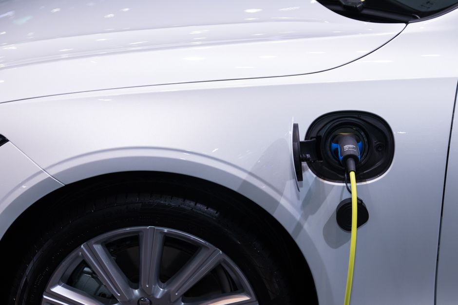 Véhicule électrique blanc branché à une borne de recharge
