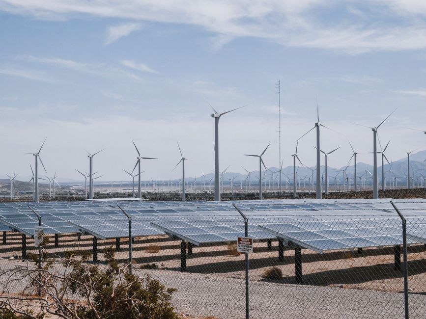 Parc d'énergie renouvelable avec éoliennes et panneaux solaires sous ciel dégagé