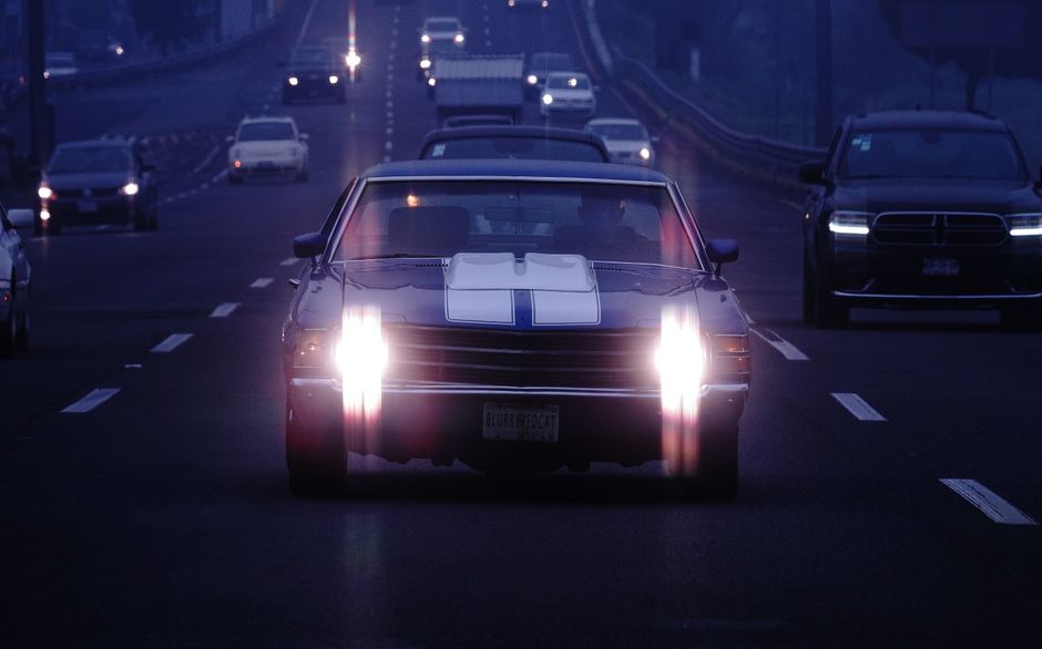 Voiture de nuit sur autoroute avec phares allumés