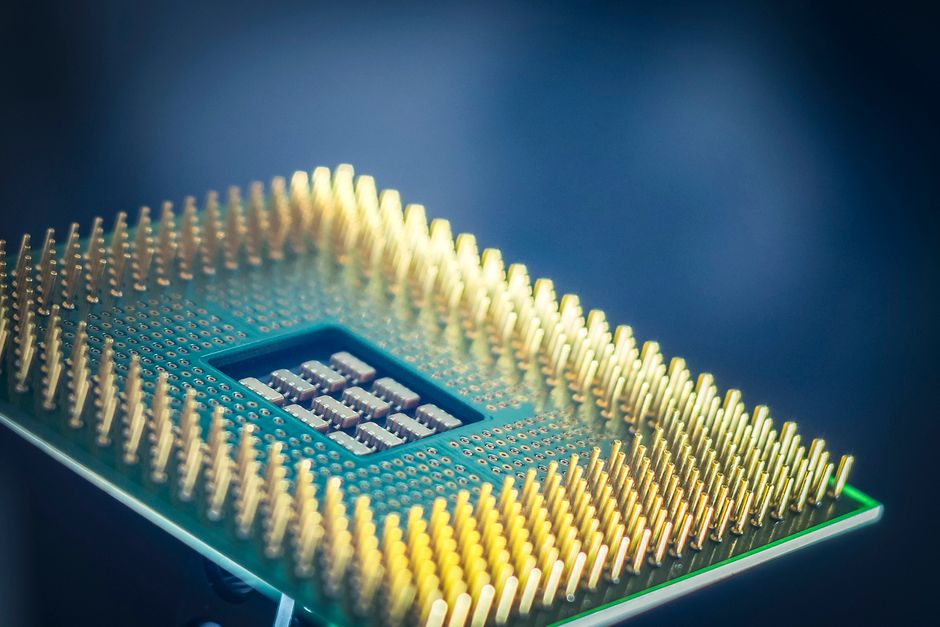 Gros plan d'une puce informatique avec broches dorées sur fond bleu