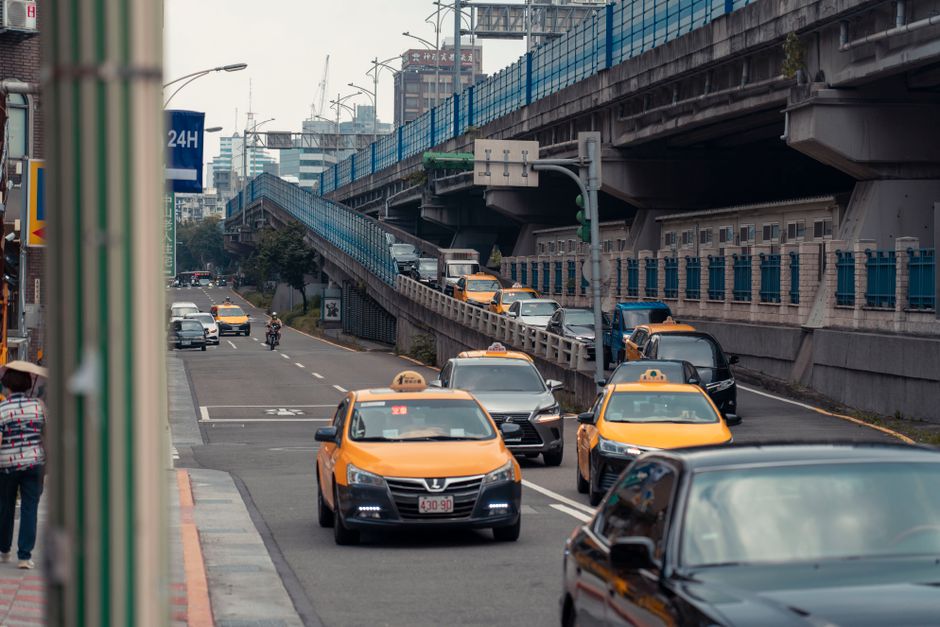 Des véhicules de transport circulant dans une rue urbaine sous un pont.
