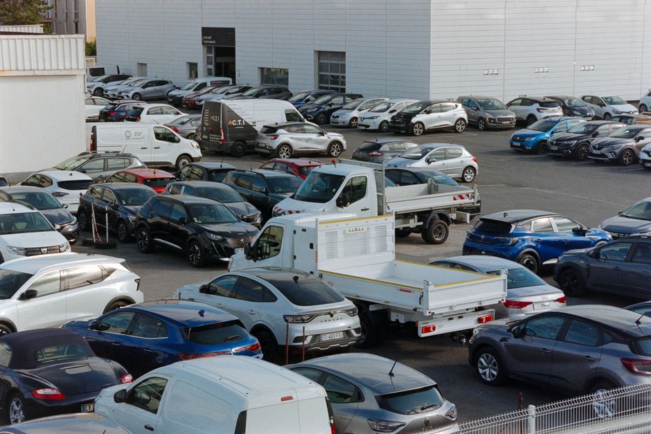 Parking avec plusieurs voitures et fourgons garés par beau temps