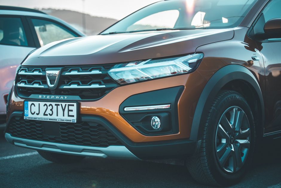 Gros plan sur l'avant d'une voiture Dacia marron avec sa calandre et ses phares