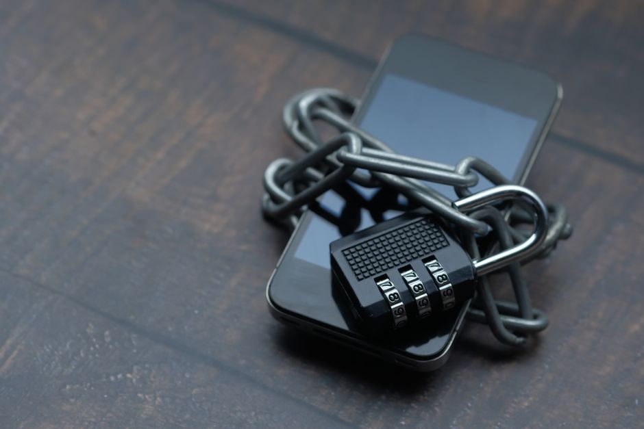 Téléphone mobile entouré d'une chaîne et d'un cadenas fermé