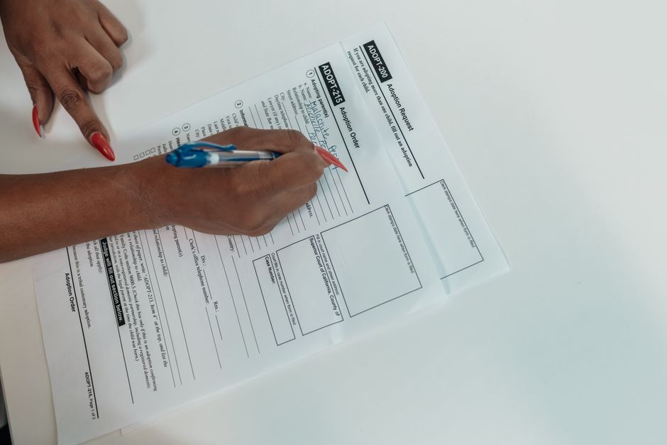 Main remplissant un formulaire de demande à l'aide d'un stylo