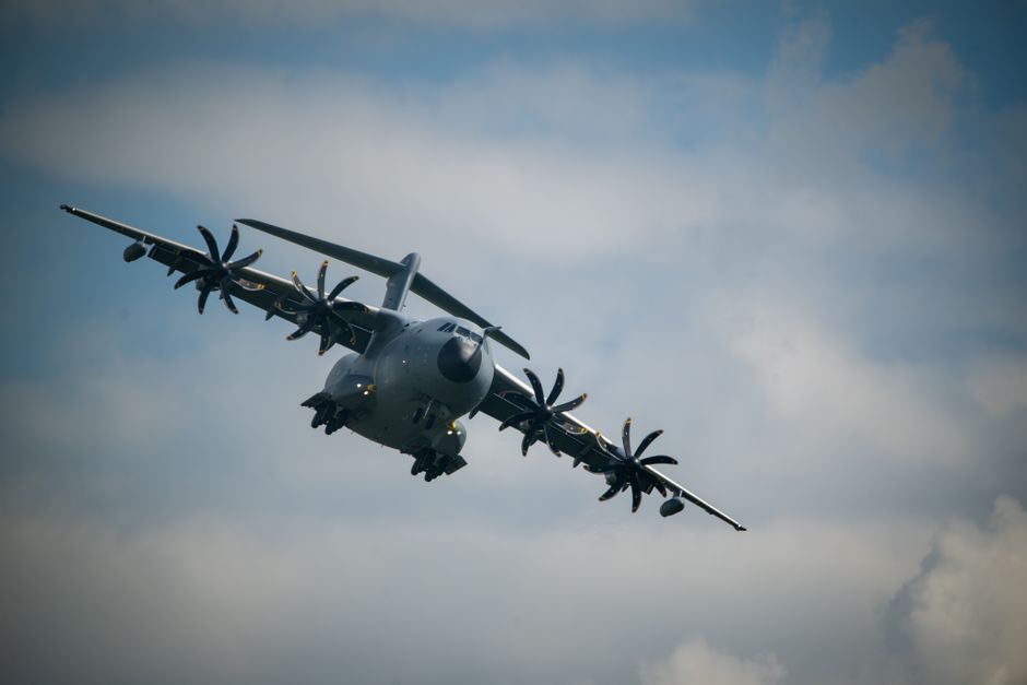 Un avion militaire de transport en vol dans un ciel nuageux