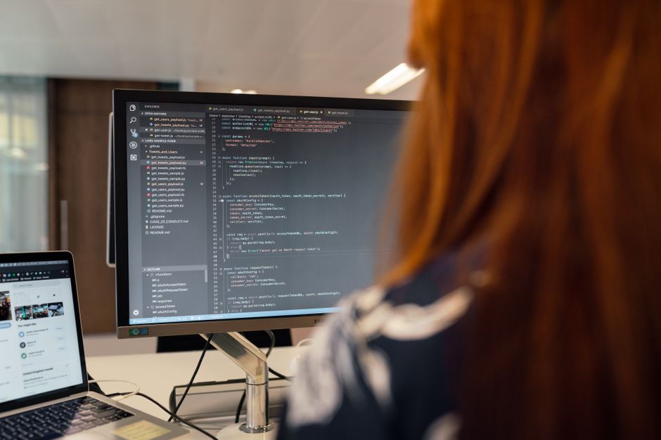 Une femme ingénieur travaille sur du code informatique dans un bureau moderne.