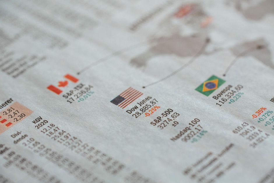 Gros plan sur un journal affichant des statistiques financières mondiales et des drapeaux de pays.