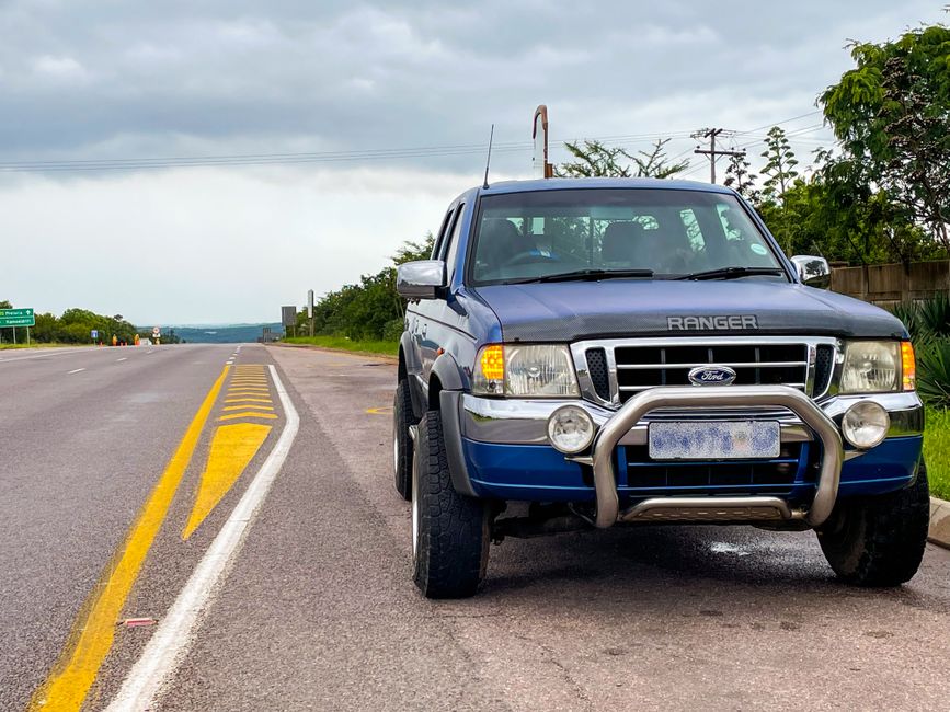 Un Ford Ranger bleu garé en bord de route dans un paysage naturel.