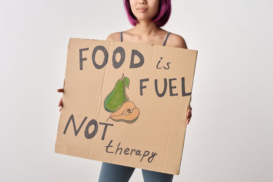 Une femme tenant une pancarte sur l'alimentation saine et équilibrée.