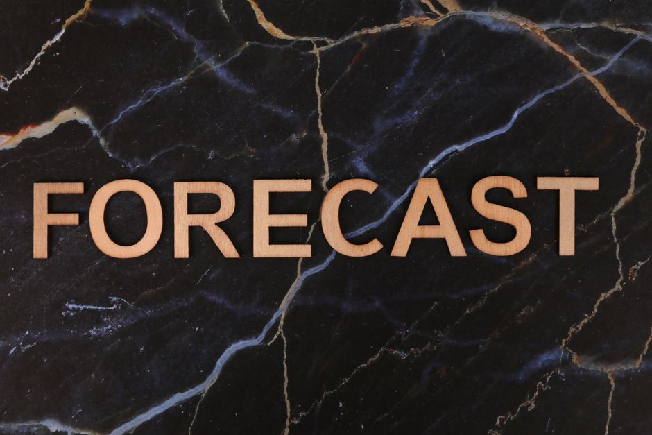 Le mot FORECAST écrit en lettres de bois sur fond de marbre foncé
