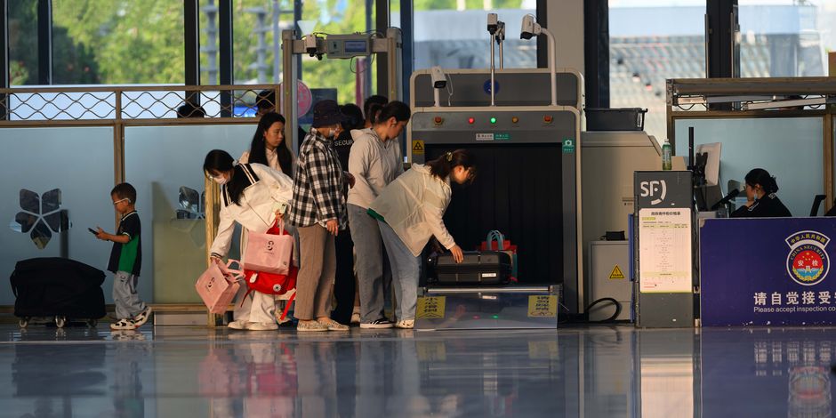 Contrôle de sécurité dans un terminal d'aéroport avec agents et passagers.