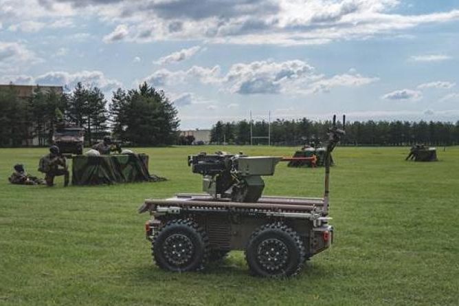 Robotisation terrestre : l’armée de Terre prépare Pendragon pour 2028 et expérimente de nouveaux robots Robot terrestre à roues déployé sur un terrain d'entraînement avec des militaires positionnés en arrière-plan