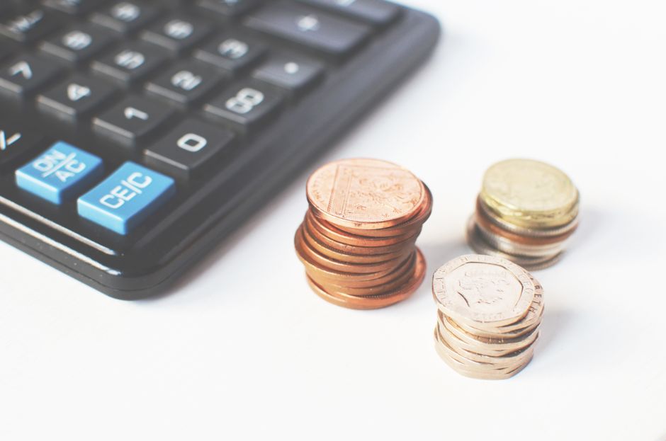 Pièces de monnaie empilées à côté d'une calculatrice