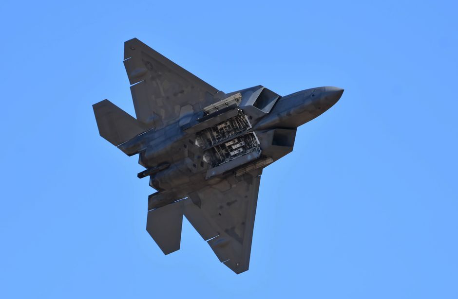 Un avion de chasse furtif vole dans un ciel dégagé.