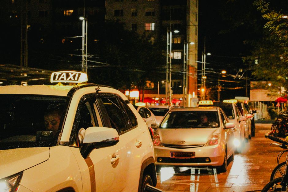 Des taxis garés la nuit sous les lampadaires d'une rue