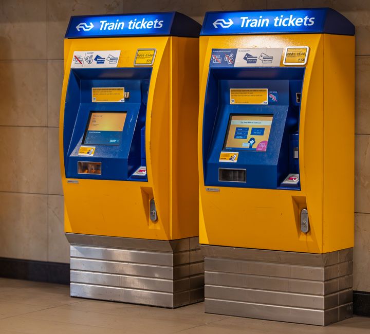 Deux distributeurs automatiques de tickets jaunes et bleus en gare