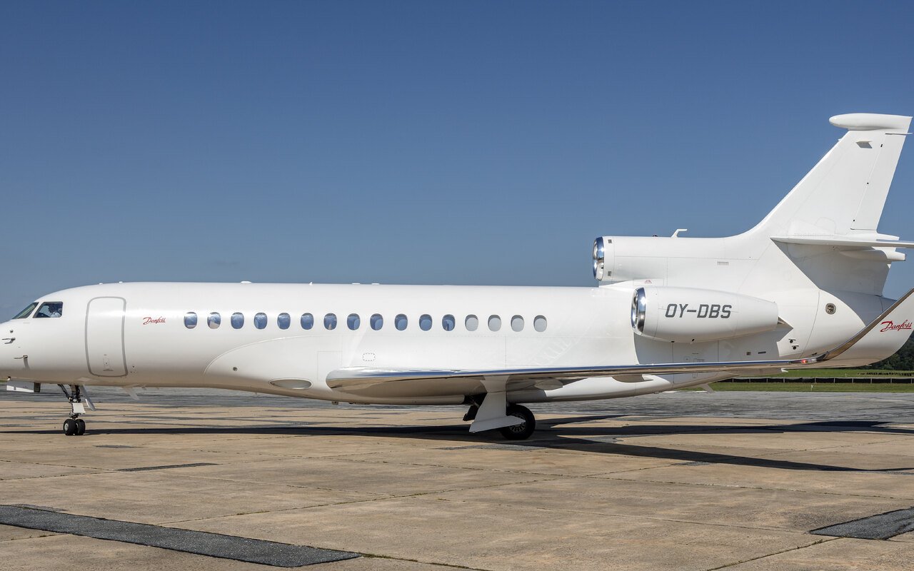 Un Falcon 8X blanc de profil sur une aire de stationnement, hublots de cabine alignés le long du fuselage