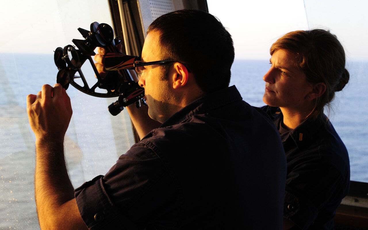 Un marin relève une hauteur d'astre au sextant depuis une passerelle