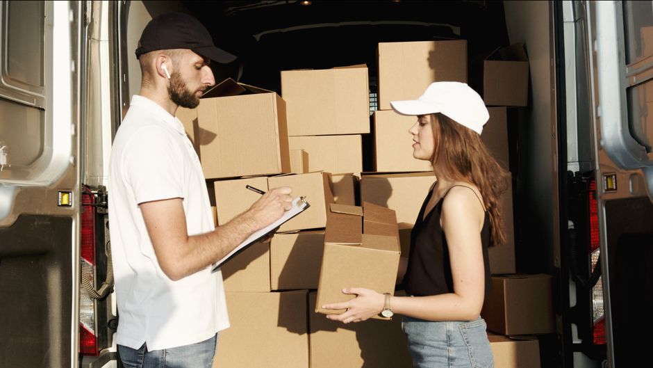 Des livreurs organisent des colis dans un camion de livraison.